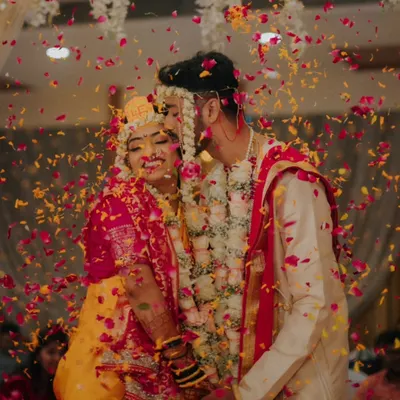 A candid moment of pure bliss as the couple is showered with flower petals. This is the kind of joyful, unposed shot I aim to capture.