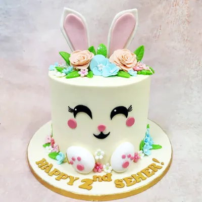 This Happy Bunny Cake is pure pastel joy, featuring a sweet bunny face, floral crown, and little paws, perfect for a second birthday.