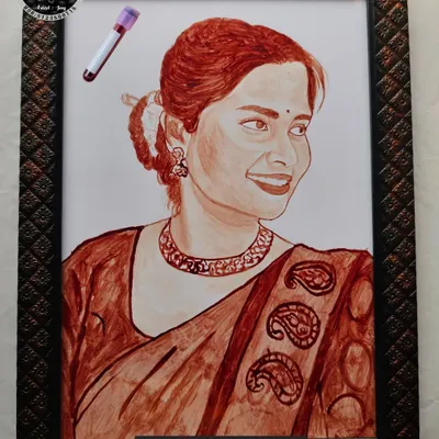 A beautifully detailed blood portrait of a woman in a traditional saree. The artwork captures her gentle smile and the intricate patterns of her clothing, all framed and ready to display.