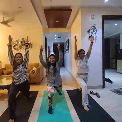 A personal group session at home with some of my dedicated students. We're practicing the warrior pose, a foundational yoga posture for building leg strength and focus.