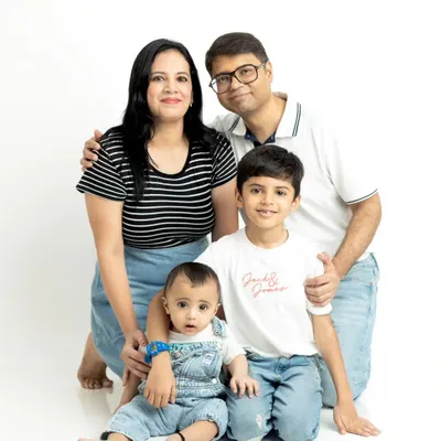 A classic family portrait against a clean white studio background. We posed this family of four to create a timeless image highlighting their connection.