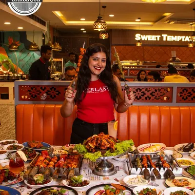 Joy in every smile, delight on every plate. We love hosting your special moments. Here's a happy guest enjoying our massive buffet spread.