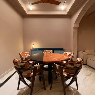 The 'Terra & Tide' dining set, designed for a post-modern space. The table features a split top of red marble and black wood, surrounded by chairs with a bold, colorful pattern.