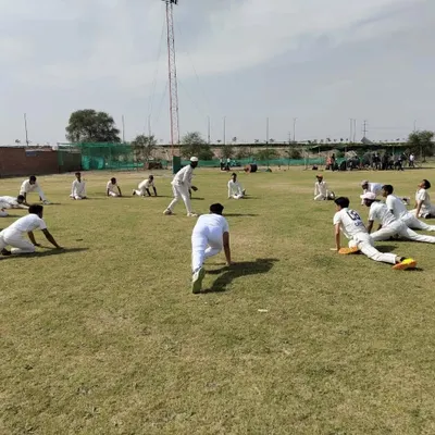 A coach guides players through dynamic stretching exercises before a net session. Proper warm-ups are mandatory at our academy to ensure every player is physically prepared for intense training and to minimize the risk of injury.