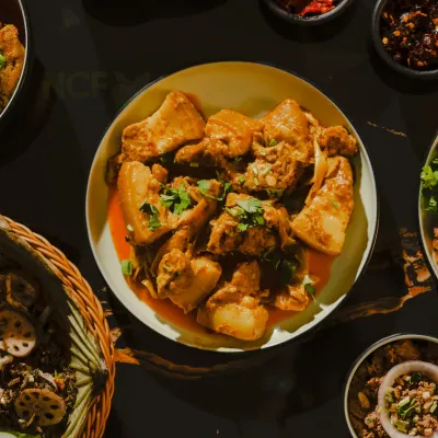 A top-down shot of my tender pork curry, surrounded by various Manipuri side dishes and chutneys.