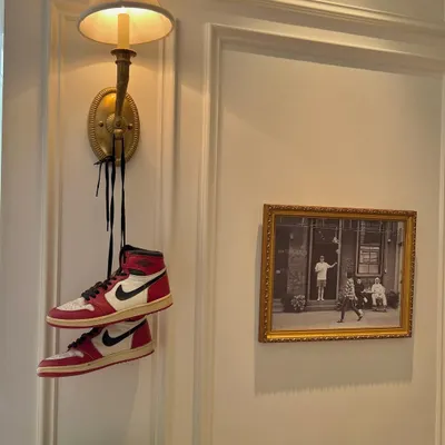 A pair of classic Air Jordans hanging from a wall sconce. This image is a whole mood, blending high-end interior design with iconic streetwear. It represents the kind of cultural fusion that I strive for in my own work.