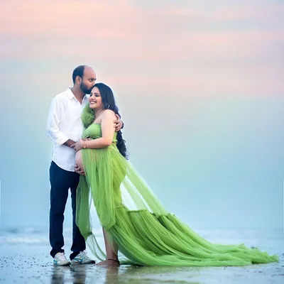 A tender kiss on the forehead against a pastel sky. This beach maternity photo captures the quiet intimacy and anticipation as the sun sets over the water.