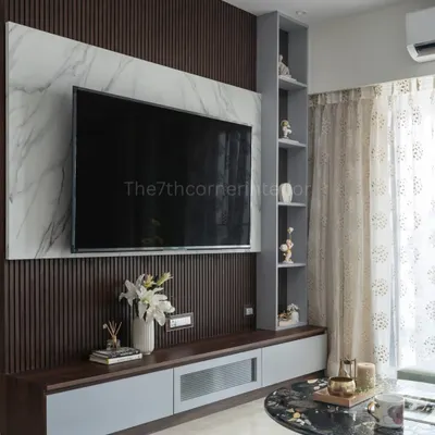 This custom TV unit is a statement of style, featuring a backlit Italian marble panel, sleek handle-less drawers, and an integrated niche with a tinted mirror for displaying art.