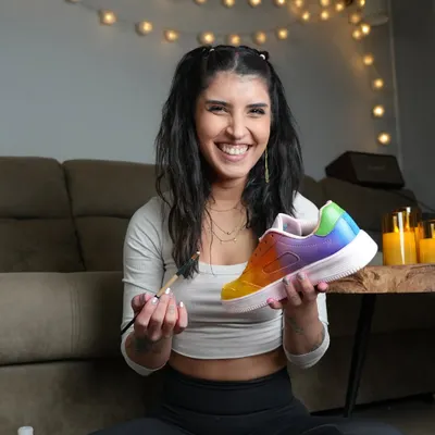 This is me in my happy place. A candid shot of me holding up a freshly painted rainbow sneaker, brush in hand. This is what it's all about.