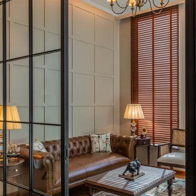 For this office at One Place Lodha, I used glass partitions to create separation without sacrificing the open, airy feel. The view into the lounge area shows a classic leather Chesterfield sofa, which adds a touch of timeless English style.