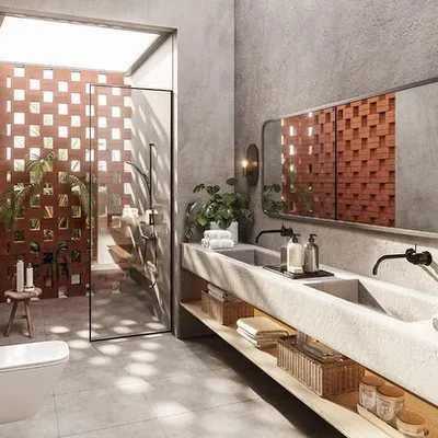 The master bathroom in our Kolgaon project features an open-air shower enclosed by a perforated brick wall. This design provides privacy while creating an outdoor feel, allowing natural light and air to fill the concrete-finished space.