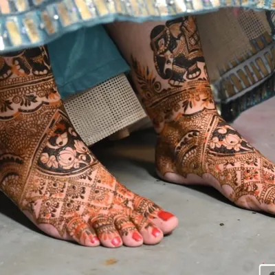 A detailed view of bridal foot mehandi, featuring traditional motifs that match the bride's overall look.