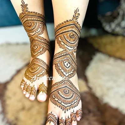 Beautiful bridal feet adorned with intricate geometric and eye-inspired patterns. This style of mehandi provides full coverage and a very traditional look.