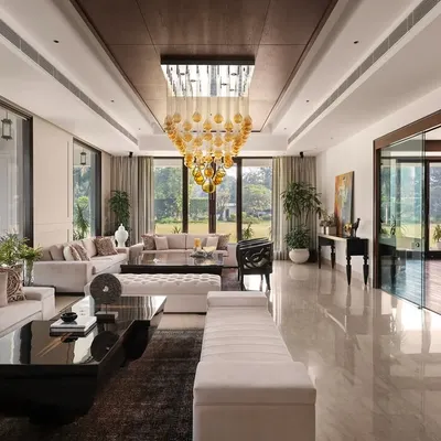 The drawing room at Mehalin Farm, featuring expansive glazing for abundant natural light. Muted wall mouldings and a statement chandelier introduce a neo-classical elegance to the spacious interior.