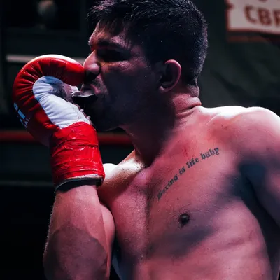 This is what it's all about. The passion, the dedication, and the quiet moment of respect for the sport. My goal is to capture the soul of the fighter, not just the fight, and this shot says it all.