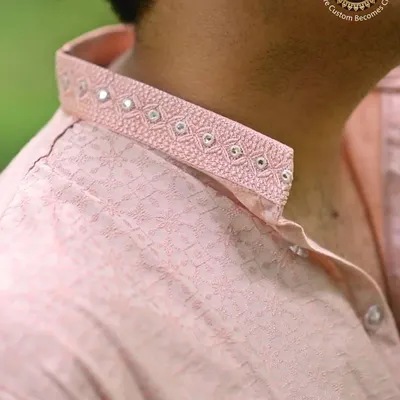 Royal weddings begin with royal style. A close-up on the collar of a pink kurta, showcasing delicate mirror work and embroidery.