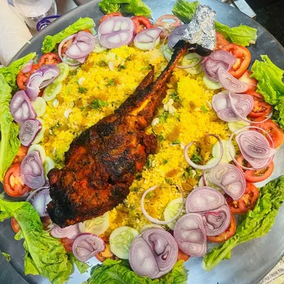 Our showstopping Mutton Mandi. A whole leg of mutton, slow-cooked and spiced, served on a bed of fragrant rice. A true centerpiece for any feast.