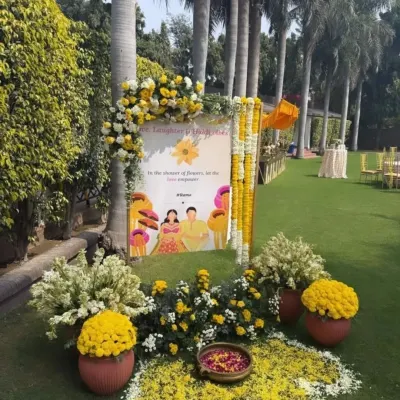 A personalized welcome sign for a Haldi function. The sign is placed on an easel and decorated with yellow and white flowers, warmly greeting guests as they arrive.