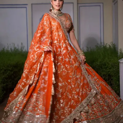 A stunning, vibrant orange lehenga by Abhinav Mishra, perfect for a grand Mehendi celebration. The wide flare of the skirt is designed for that perfect twirl.