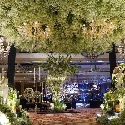 We created a forest of baby's breath for a landmark 70th birthday celebration. The entrance featured a breathtaking ceiling of white florals and chandeliers, leading into a space designed for honoring a lifetime of memories.