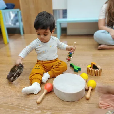 I just love watching children explore musical instruments on their own terms. Here, little Yohaan is discovering the different sounds of a tambourine, maracas, and a gathering drum all at once.