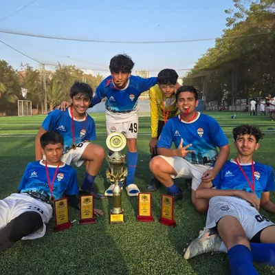 Our U15 team celebrating a major tournament win against other top academies in the city, surrounded by their trophies and medals.