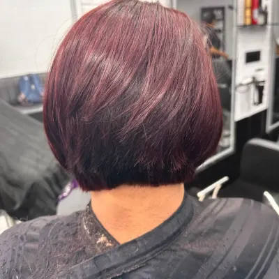 A perfect example of a classic bob haircut. This short, sharp style is given a modern twist with a bold burgundy color, creating a look that is both timeless and edgy.
