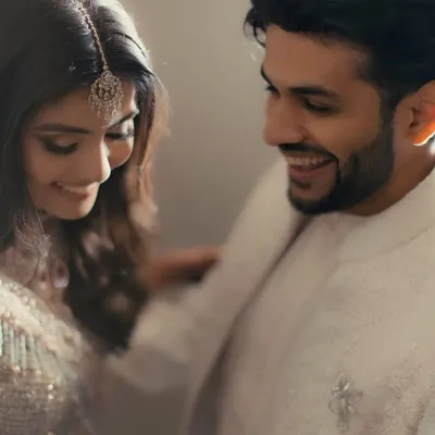 It's the small, unscripted gestures that we love to capture. This candid shot of a shared smile and a gentle touch on the shoulder speaks volumes about their easy, comfortable love.