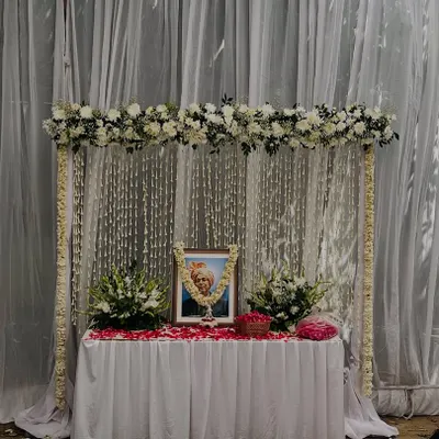 A serene and respectful memorial setup. I created a frame of white flowers with a backdrop of hanging 'rajnigandha' strings to pay tribute.