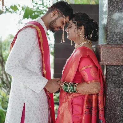 The quintessential Maharashtrian bride and groom. Her look is complete with the traditional headpiece, green bangles, and a makeup style that is both classic and radiant.