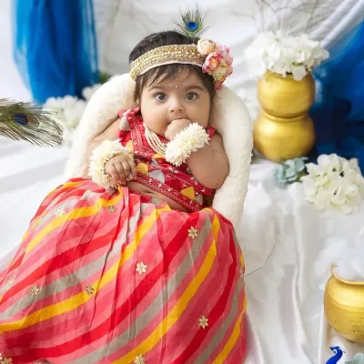 Our little Radha celebrating Janmashtami. The colorful lehenga, peacock feathers, and pots of 'butter' create a beautiful and traditional scene for the festival.