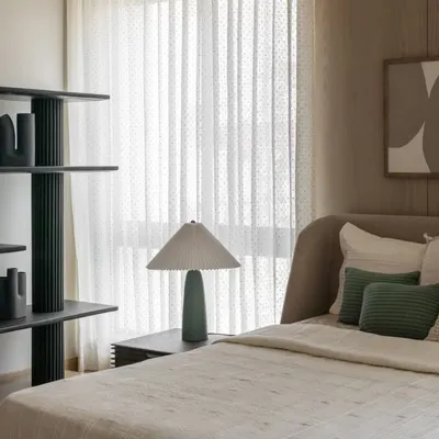 A guest bedroom in the Aikaa show villa in Hyderabad. We focused on understated luxury, using a palette of soft greens and beiges, layered textures, and clean lines to create a welcoming and serene space.