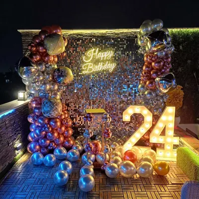 A full view of the shimmer sequin wall decoration, perfect for a milestone birthday party. This setup combines the sparkling backdrop with marquee numbers, a neon sign, and a dense, multi-colored balloon arrangement to create a vibrant photo corner.