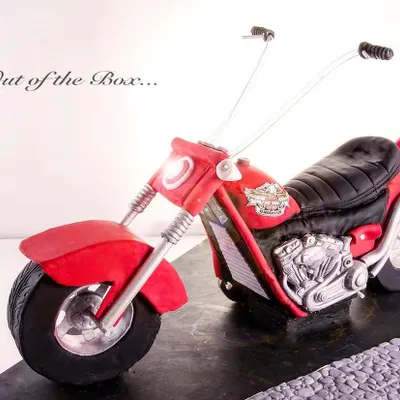 A stunning, life-like 3D Harley Davidson motorcycle cake, sculpted with incredible attention to detail, from the engine to the handlebars.