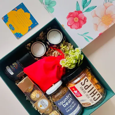 This beautiful teal gift box is curated with a mix of gourmet snacks like Peri Peri Quinoa Chips, Country Bean coffee, Ferrero Rocher, and scented candles.