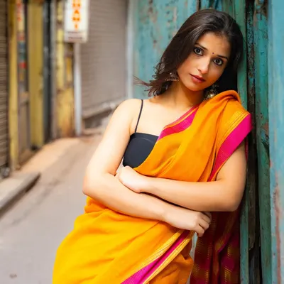 Finding a quiet, colorful alley in Old Delhi. The contrast between the bright yellow saree and the weathered blue door creates a stunning visual.