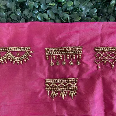 A sampler of different Aari embroidery border designs on pink silk fabric. These patterns are perfect for sleeve hems, necklines, or the edges of a dupatta.