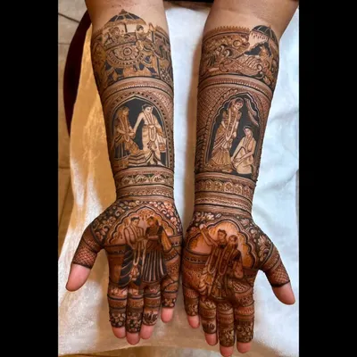 This full-arm bridal design is a canvas for this couple's story, featuring multiple vignettes from their wedding ceremonies, including the varmala and pheras, rendered with incredible detail.