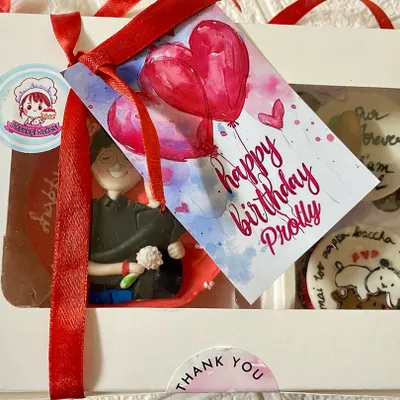The complete gift experience. We package our custom bakes in a beautiful window box, tied with a ribbon and a personalized 'Happy Birthday' tag for that extra special touch.