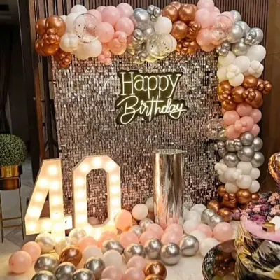 A glamorous 40th birthday celebration with a silver sequin wall. The backdrop is framed by a beautiful arch of rose gold, pink, and silver balloons, complete with a large light-up number '40'.