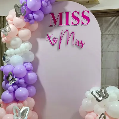A close up of our popular 'Miss to Mrs' arched backdrop. The crisp lettering stands out against the soft pink panel, while the organic balloon garland with silver butterfly accents adds a touch of whimsy. This is a fantastic choice for a daytime bridal shower.