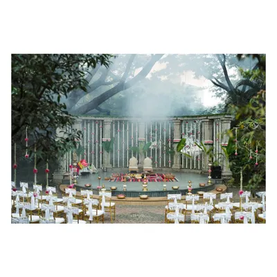 A wide view of the traditional wedding ceremony at Shankaraa Foundation, showing the seating arrangement facing the magnificent stone amphitheater mandap. The misty atmosphere adds a layer of mystique and romance to the sacred proceedings.