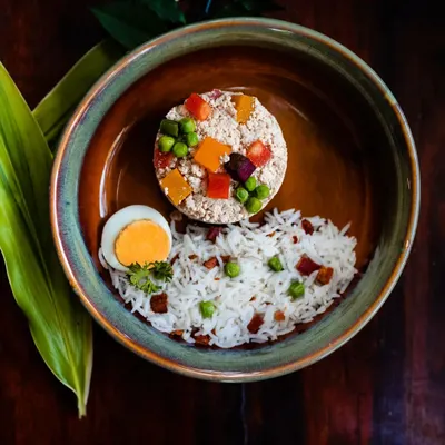This is my Chicken Keema Box, a complete meal featuring bacon and egg fried rice alongside a molded patty of minced chicken and finely diced vegetables. It's a beautifully balanced and nutrient-dense option for any dog.