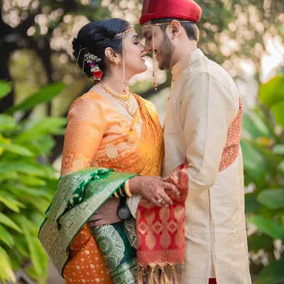 An intimate moment between the bride and groom, showcasing the traditional Maharashtrian mundavalya and their coordinated wedding attire.