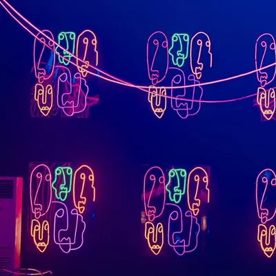 We used custom neon signs with abstract face motifs to decorate the walls. The multi-colored lights created a vibrant, artistic, and energetic atmosphere, perfect for a modern party.