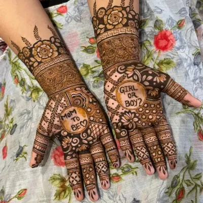 A fun and personalized henna design for a baby shower. One palm says "Mom to be" and the other asks "Girl or Boy?", surrounded by floral and traditional patterns.