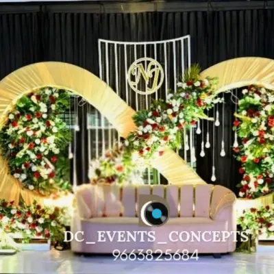 A unique and symbolic engagement stage featuring a golden infinity symbol adorned with flowers. This design represents eternal love and creates a stunning, modern backdrop for the couple.
