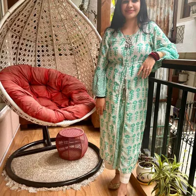 This is my cozy corner on the balcony, featuring my favorite swing chair. It's the perfect spot to relax. The wooden flooring and green plants add to the calm and natural feel of this outdoor space.