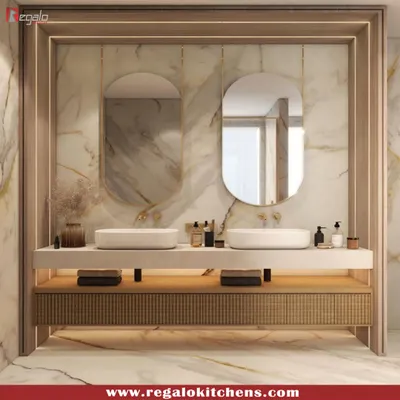 A stunning vanity design featuring a marble countertop, dual vessel sinks, and elegant oval mirrors. The reeded wood cabinetry and soft lighting create a spa-like atmosphere.
