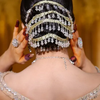 A close-up of an intricate bridal bun with beautiful beaded accessories. I teach you how to create clean, elegant hairstyles that last all day.